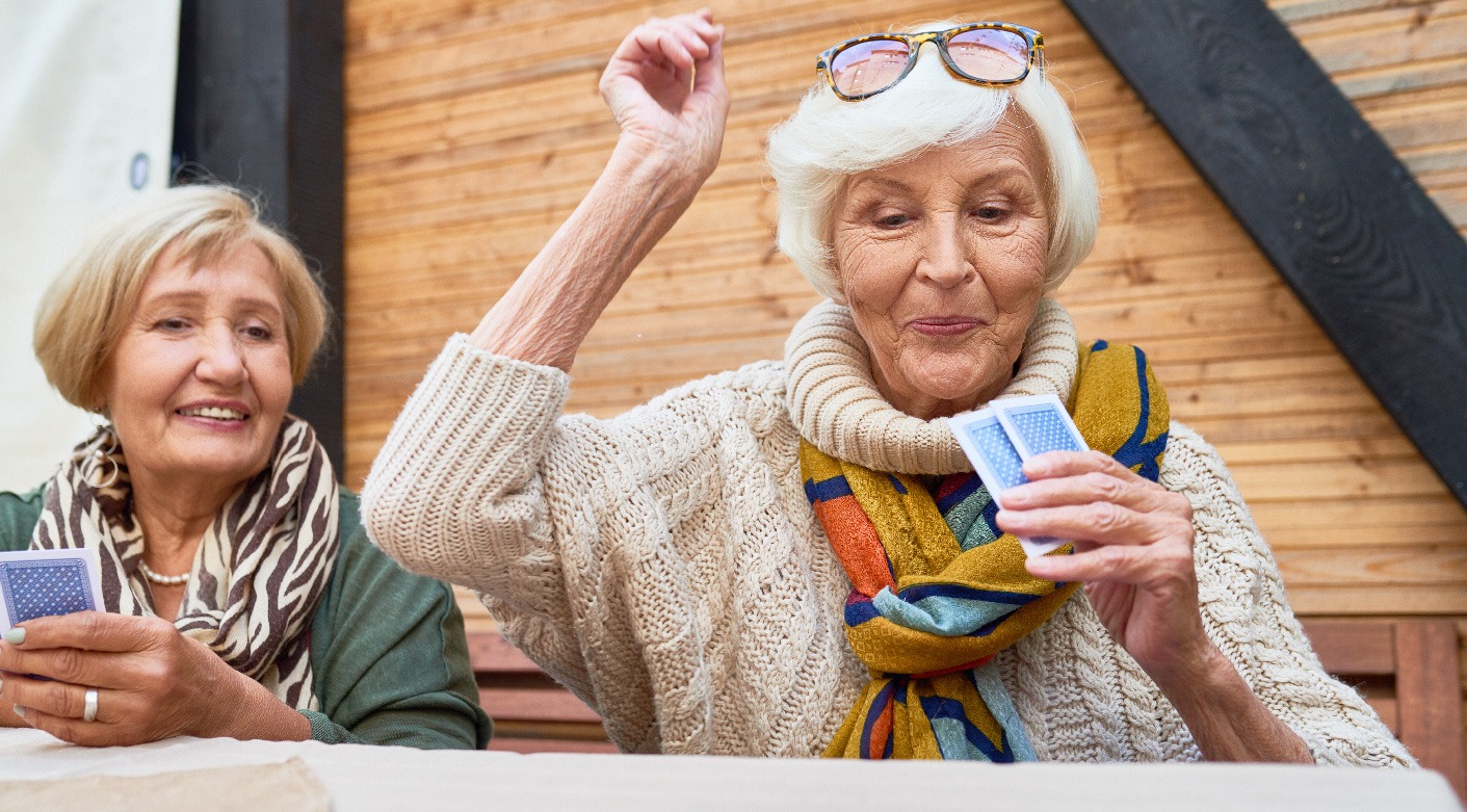 Deux femmes seniors qui jouent aux cartes dans le club house des Hameaux du Levant